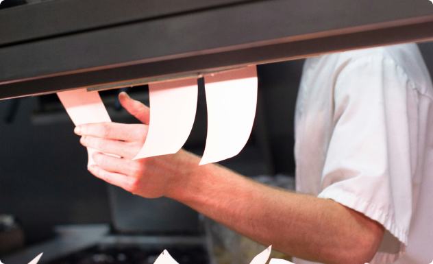 Main d'homme qui prend uen feuille avec une commande dessus